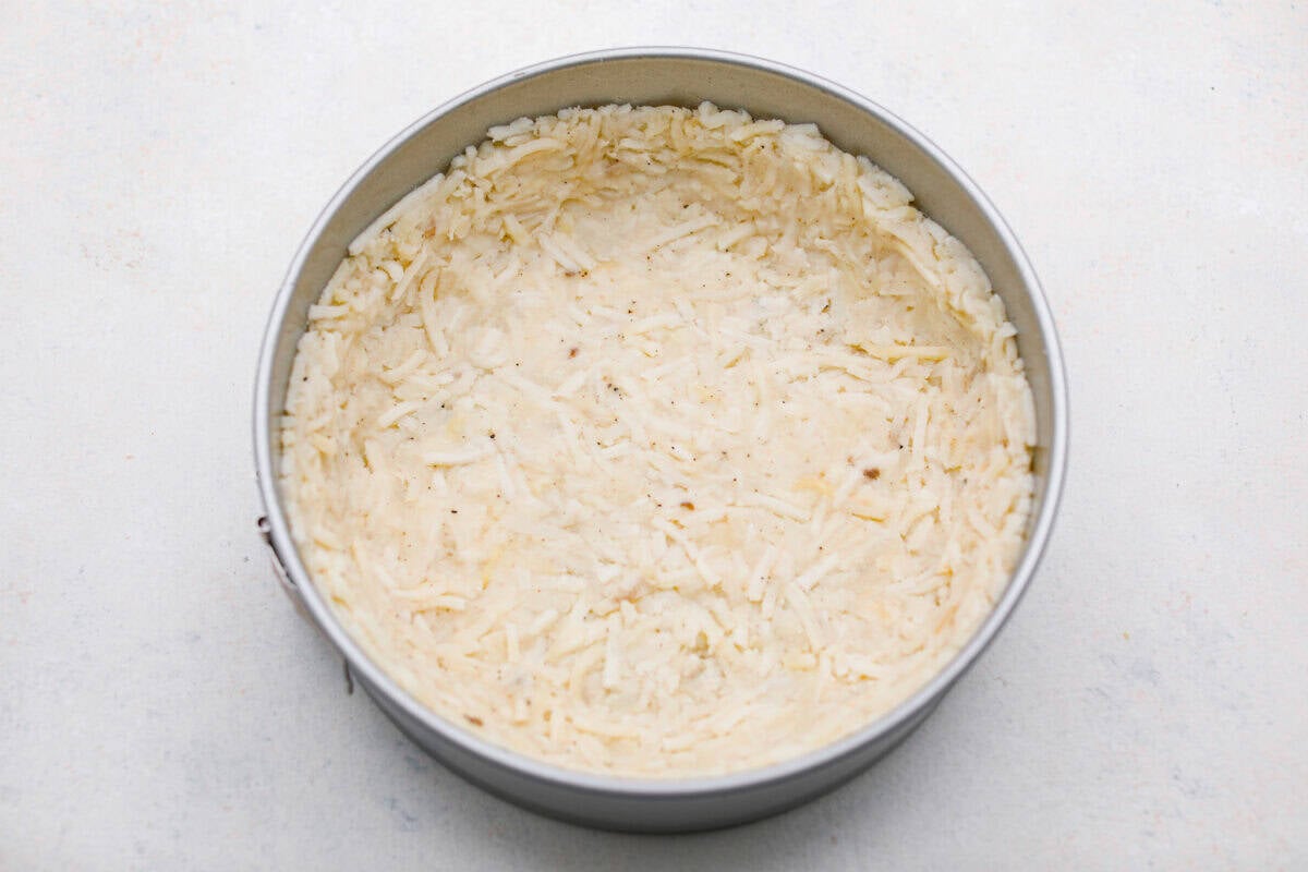 Hash brown mixture pressed firmly into the spring form pan. 
