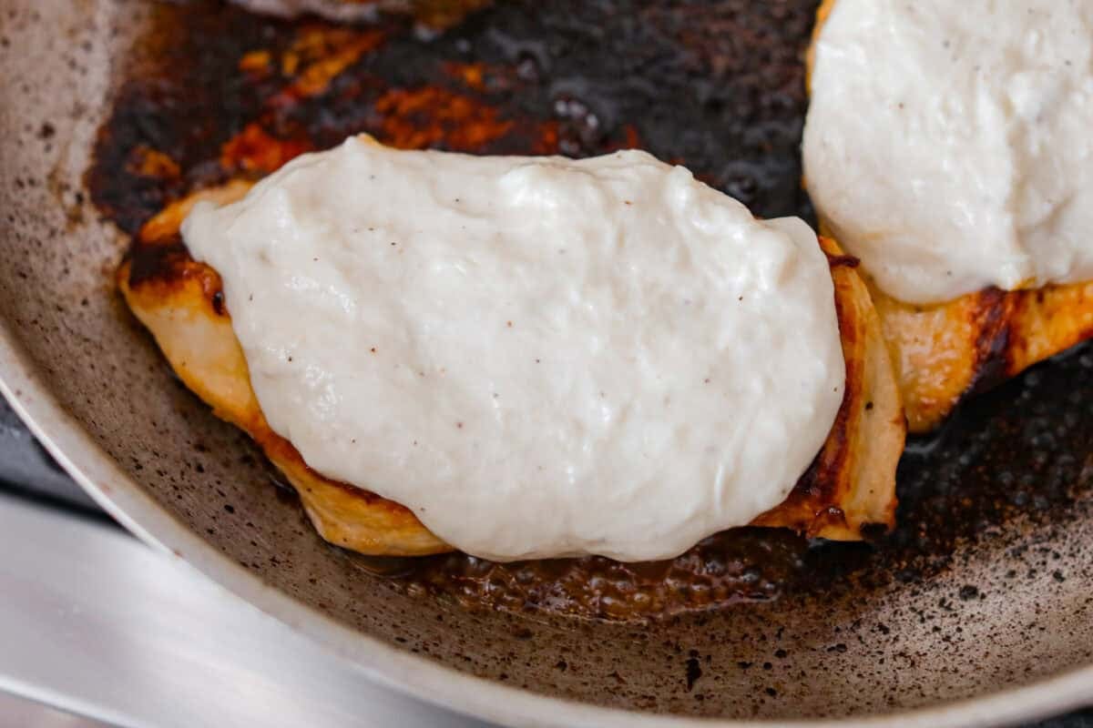 Browned cooked chicken topped with cheesy ranch sauce.