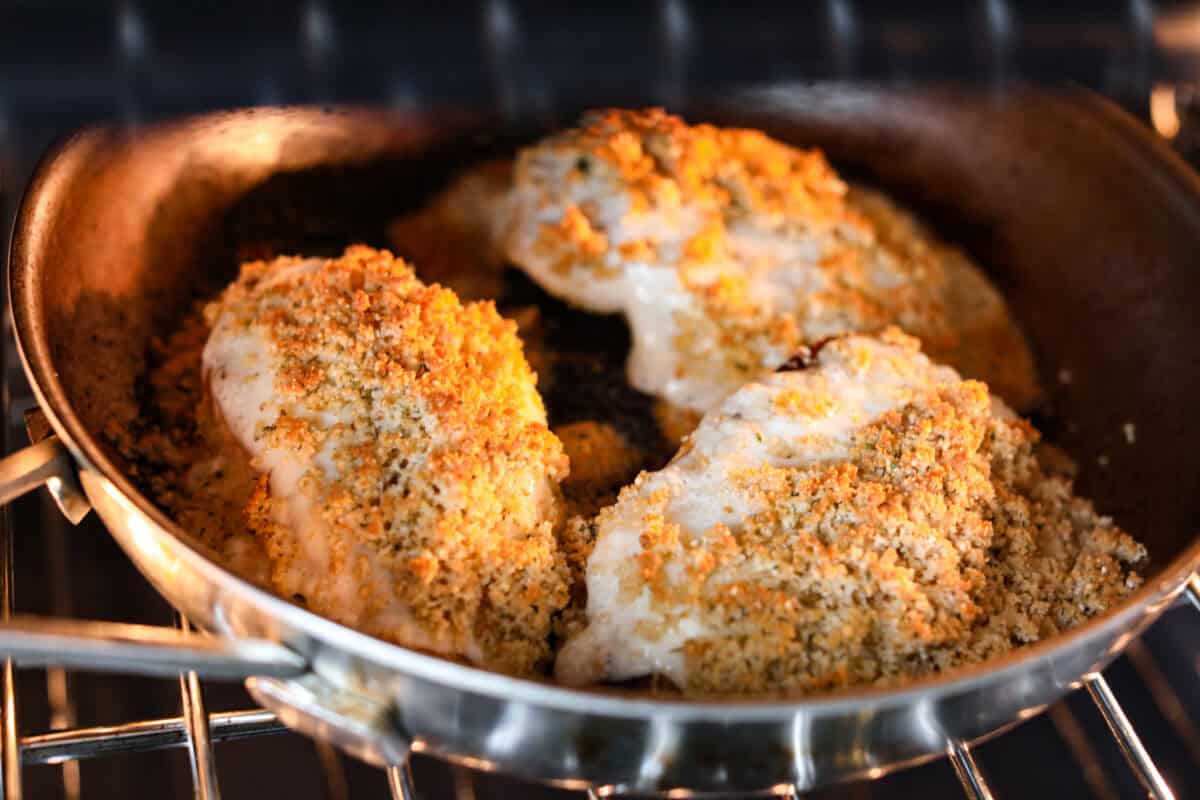 Longhorn parmesan crusted chicken in the skillet placed in the oven to broil. 
