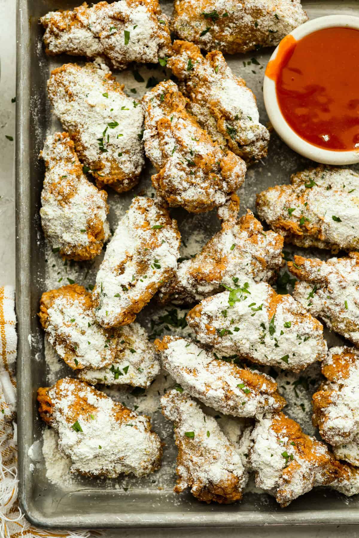 Cookie sheet with crack wings covered in the crack chicken seasoning powder. 