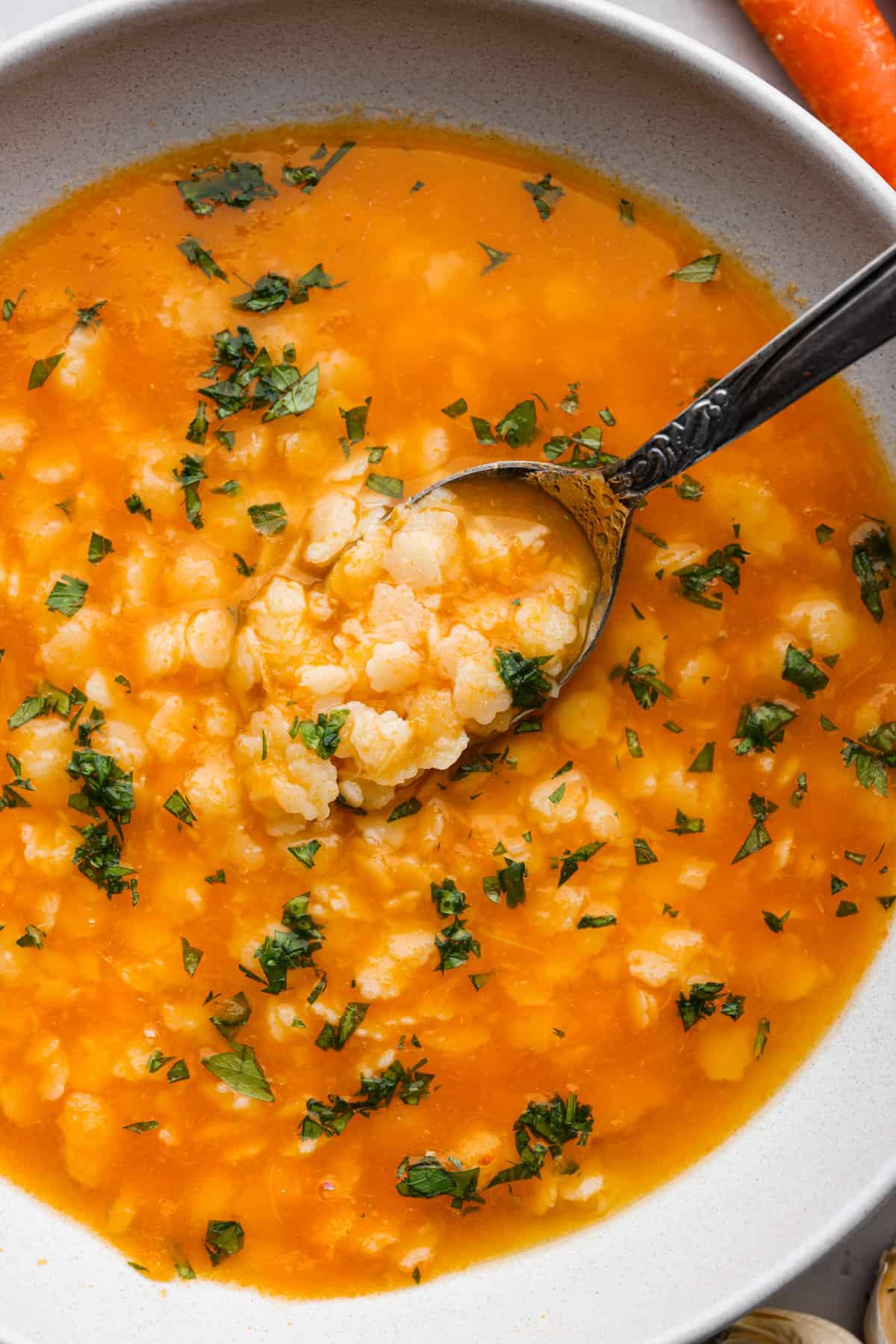 Pastina served in a white bowl with a spoon.