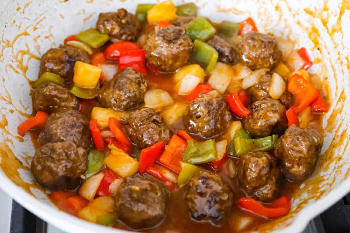 Sauce and sweet and sour meatballs ingredients all combined in a skillet.