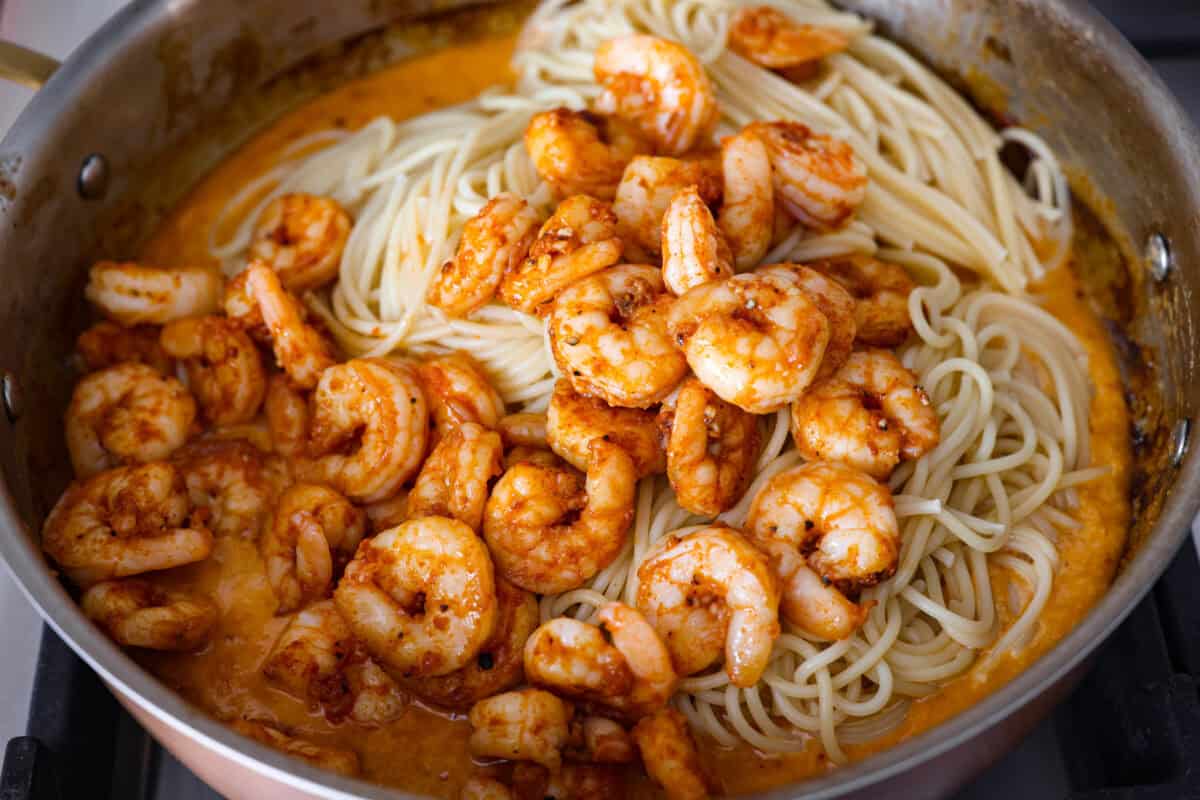 Shrimp and pasta added to the bang bang sauce in the skillet.