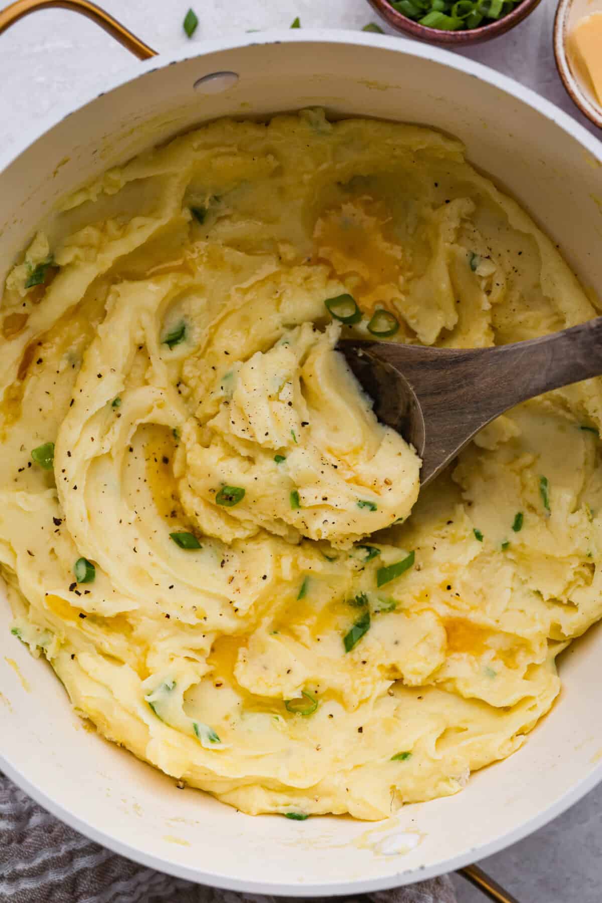 Irish champ potatoes in a saucepan with a wooden spoon. 