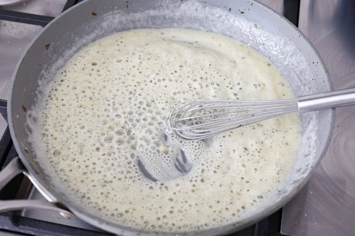 Overhead shot of butter, and flour being whisked together in a hot skillet. 