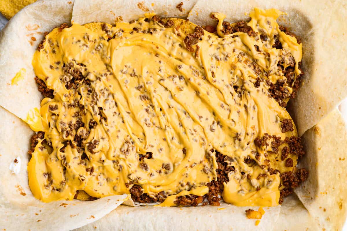 Nacho cheese layered and spread out over the top of the ground beef. 