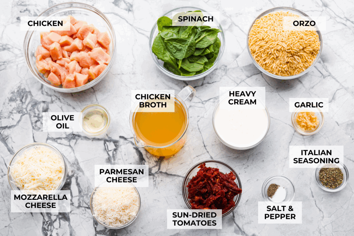 Overhead shot of labeled tuscan chicken orzo bake ingredients.