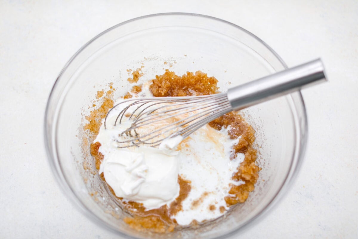 Sour cream and buttermilk added to the mixing bowl with the sugars and oil mixed together. 