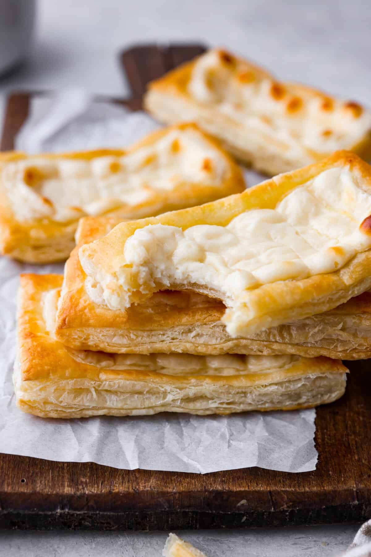 Angle shot of stacked Starbucks cream cheese danishes. One has a bite taken out. 