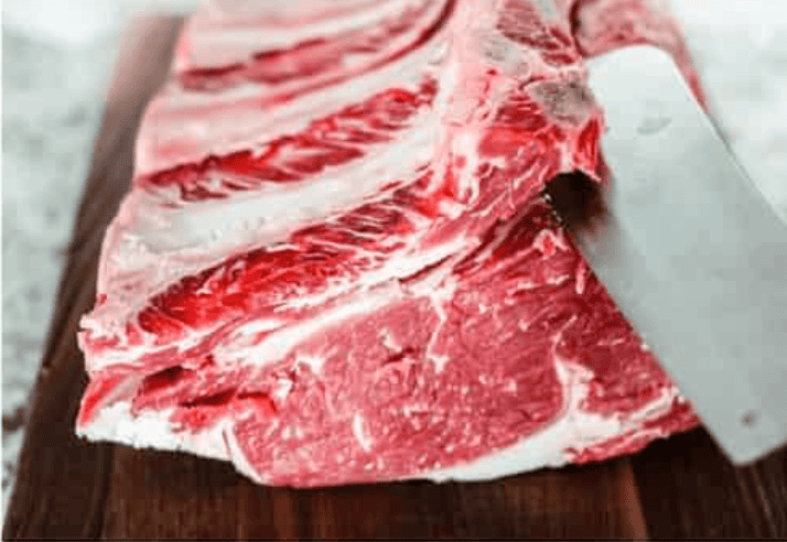 Prime rib roast being cut and prepped for wrapping.