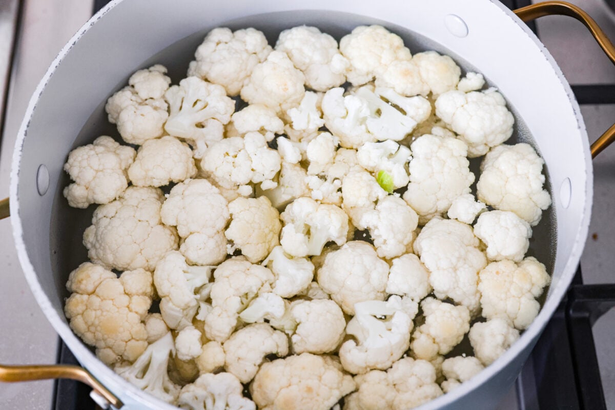 Cauliflower florets in a pot of water. 