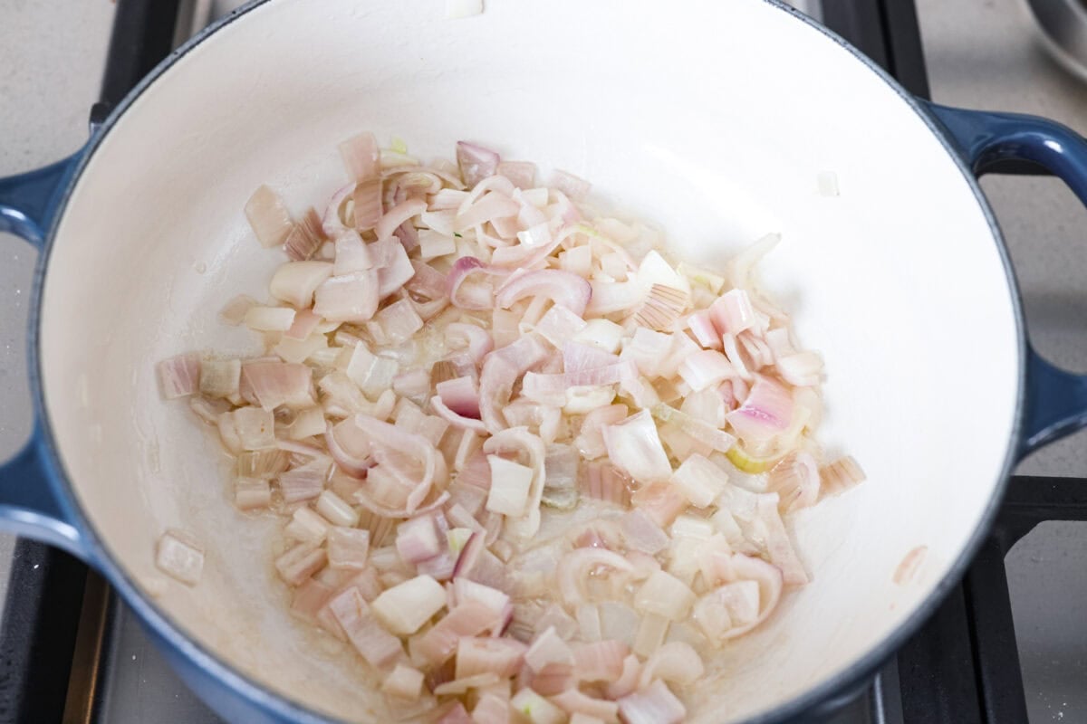 Shallots cooking in butter in a skillet.