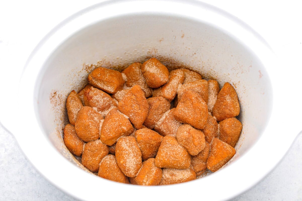 Overhead shot of cinnamon sugar biscuit dough in the bottom of the crock pot. 