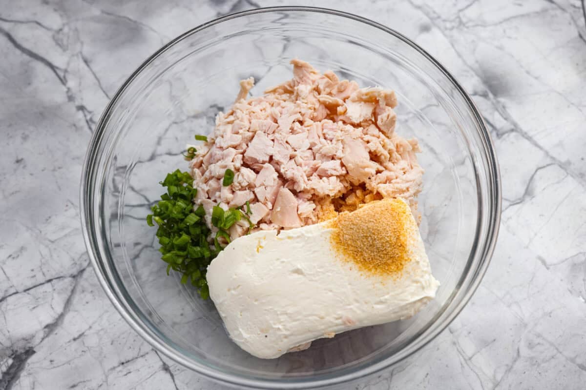 Overhead shot of all of the chicken mixture ingredients added to a mixing bowl. 