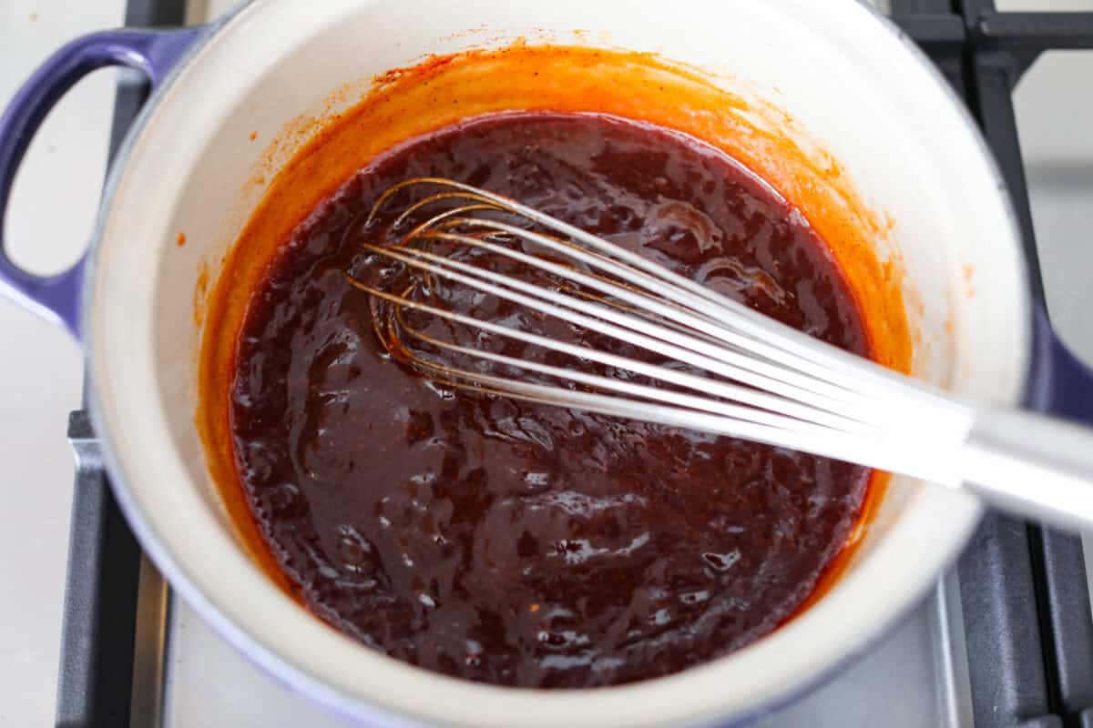 All of the sauce ingredients combined into a pot and simmering on the stove.