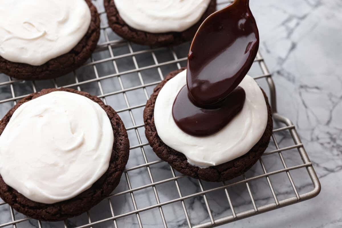 Someone spooning on a dollop of chocolate ganache. 