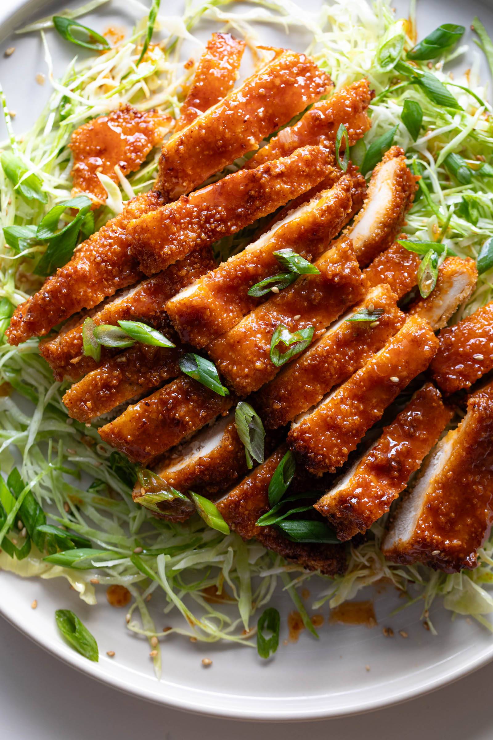 Crispy gochujang chicken on top of shredded cabbage.