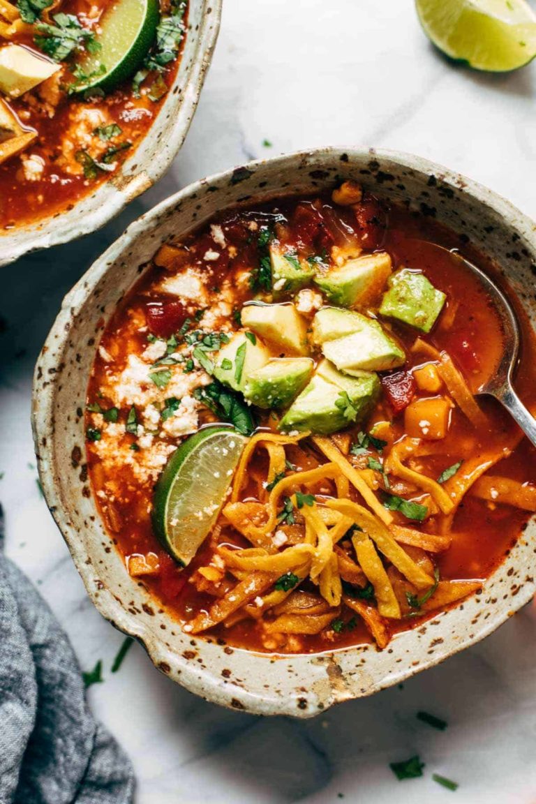 Sweet potato tortilla soup in a bowl with avocado and crispy tortilla strips.