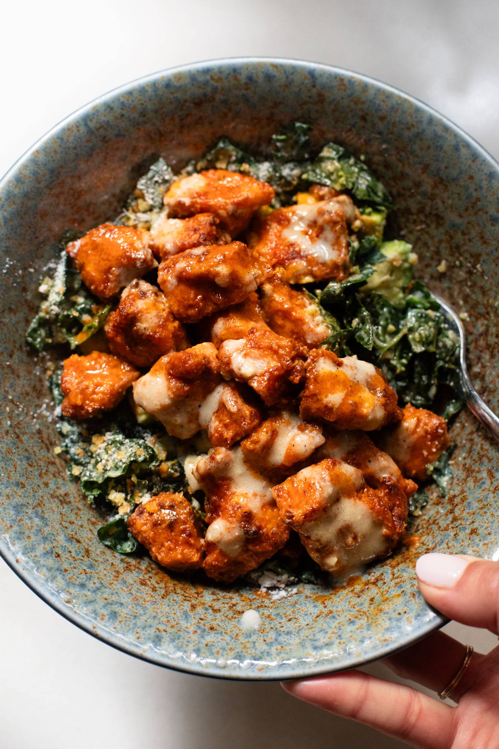 Buffalo tofu on kale caesar salad.