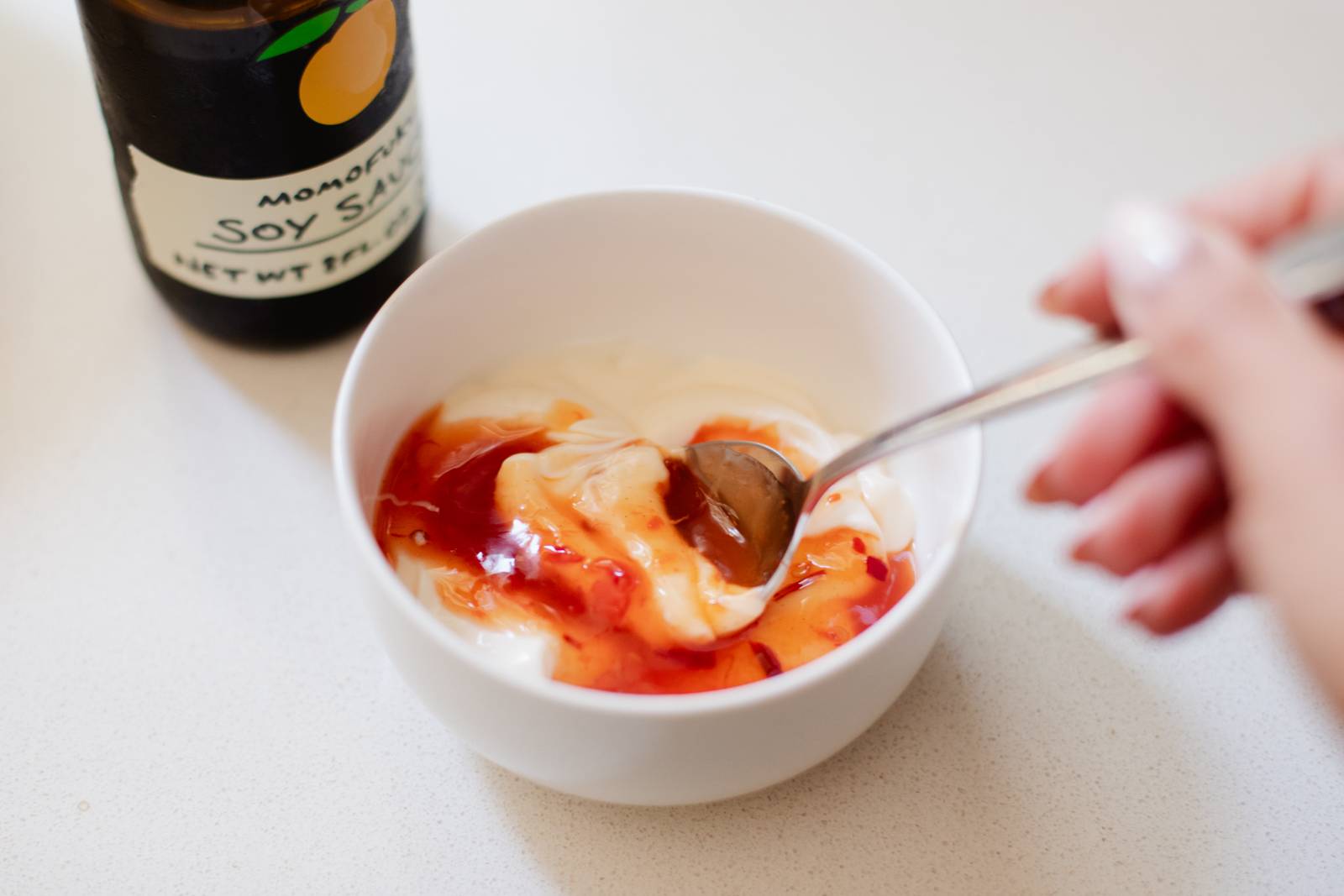 Mixing bang bang sauce in a bowl.