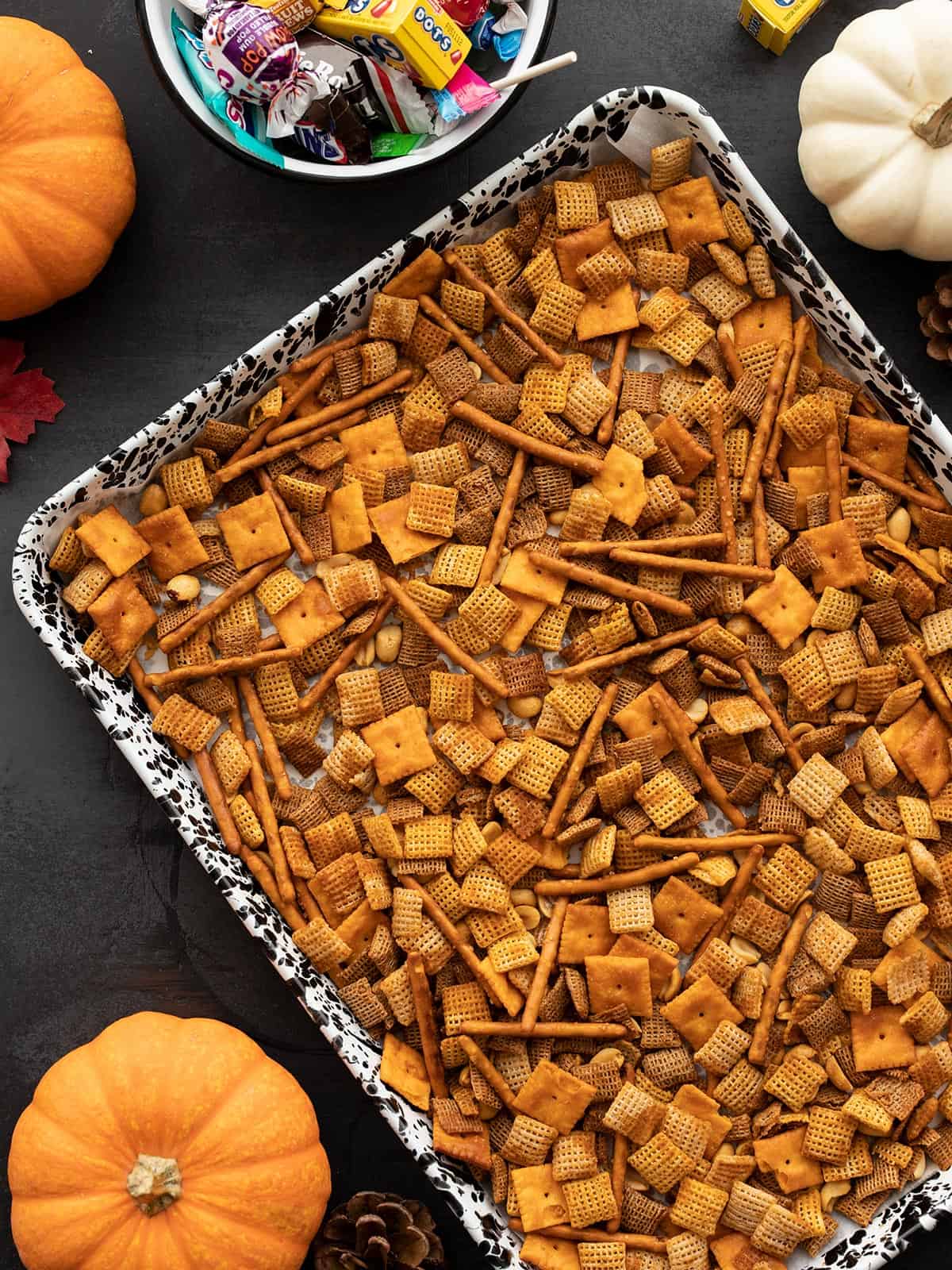 Spicy chex mix on a baking sheet with fall ornaments on the sides