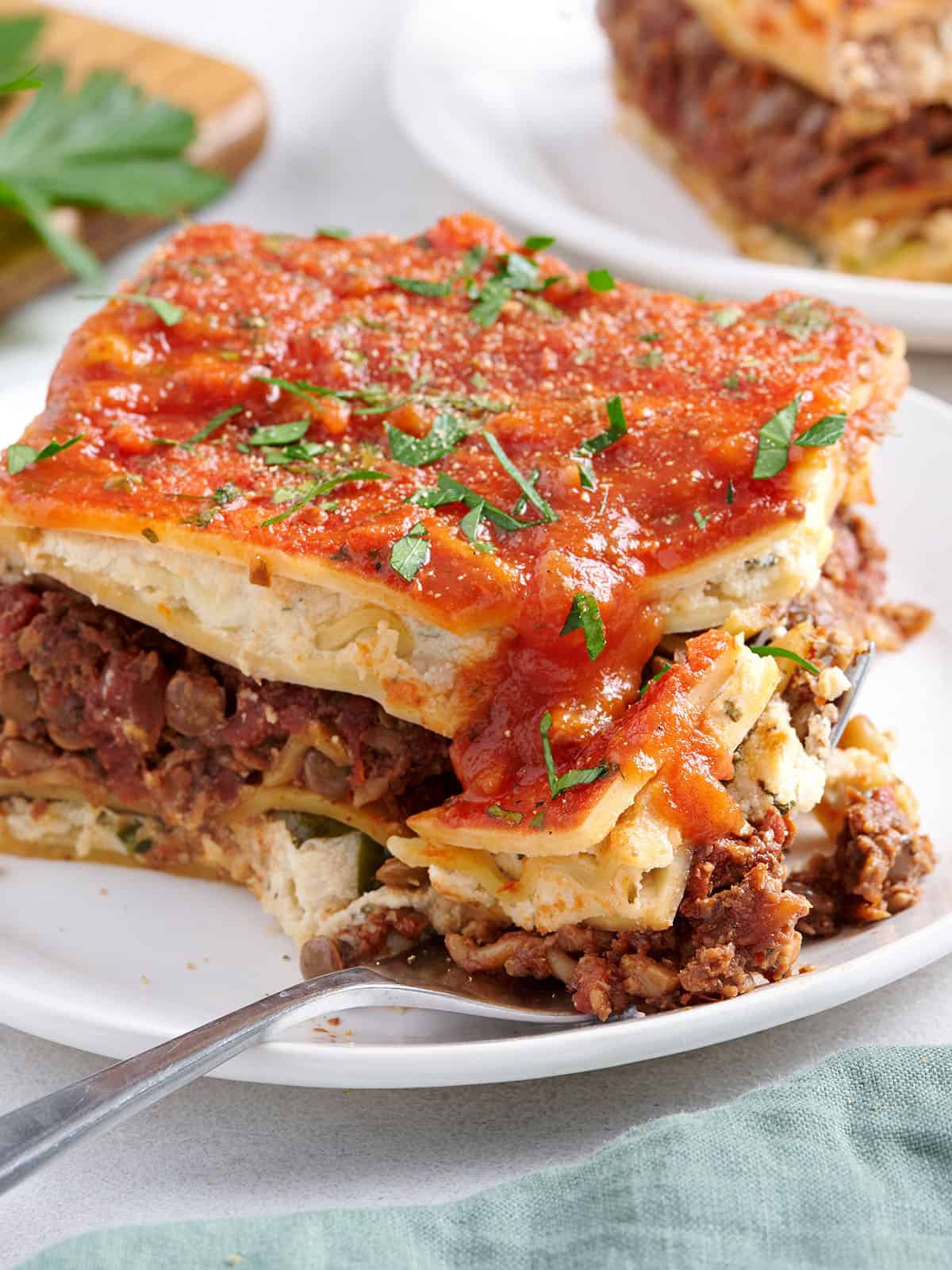 Side view of a slice of vegan lasagna with a fork.