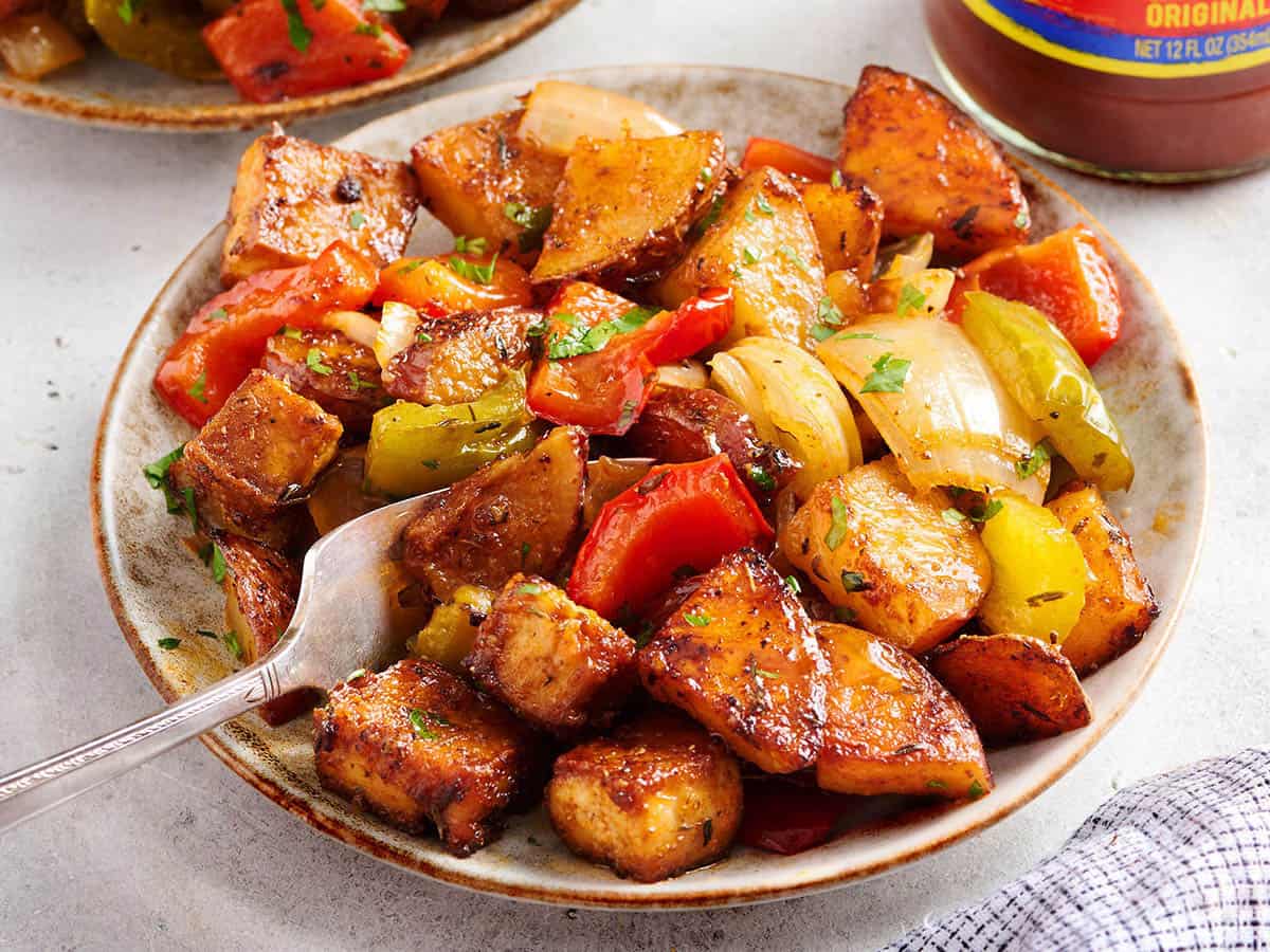 A plate of Sheet Pan Cajun Tofu and Vegetables with a fork. 