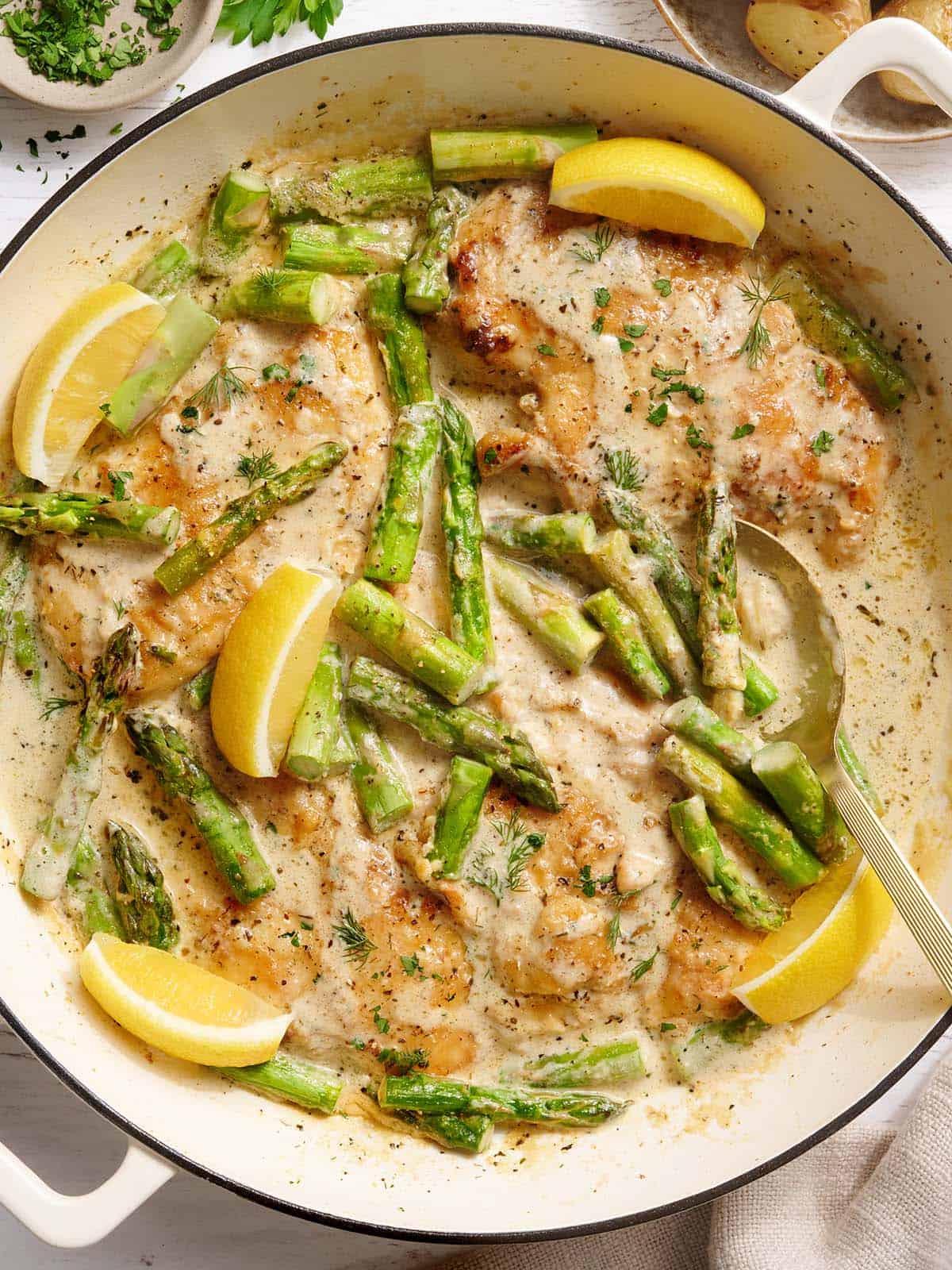 Overhead view of creamy asparagus chicken in a skillet.