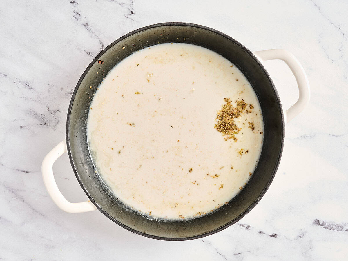 Seasonings, broth and spices added to a skillet to make a cream sauce.
