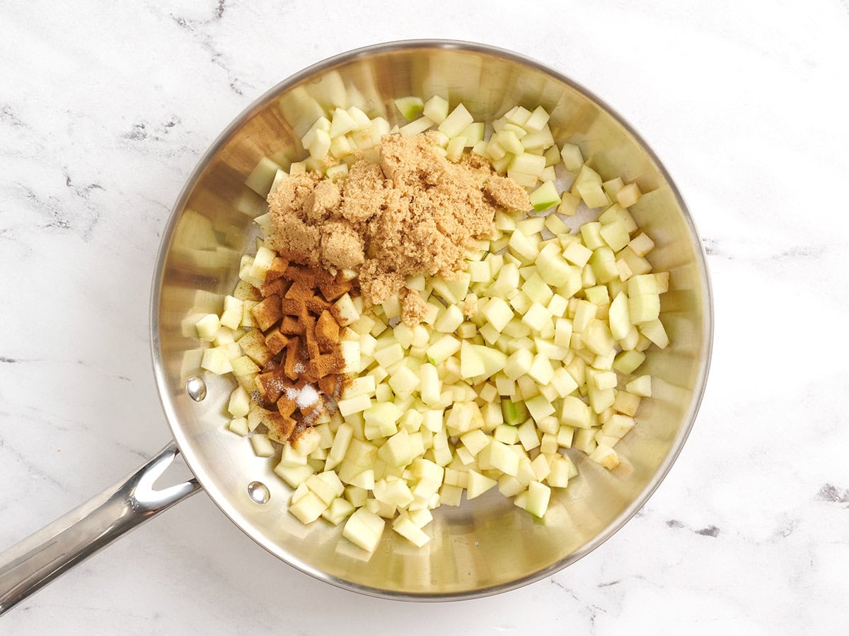 Diced apple, brown sugar, and spices in a skillet.