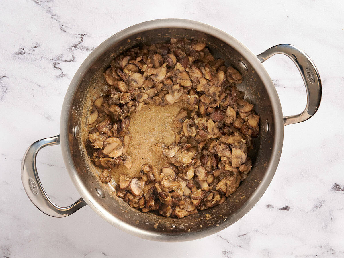 Mushrooms sauteing in a skillet.