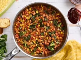Overhead view of a skillet of bbq beans and greens.
