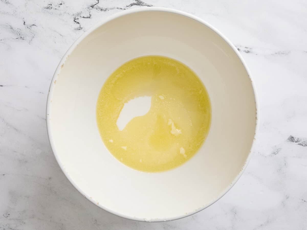 Melted butter, oil, and sugar in a bowl.