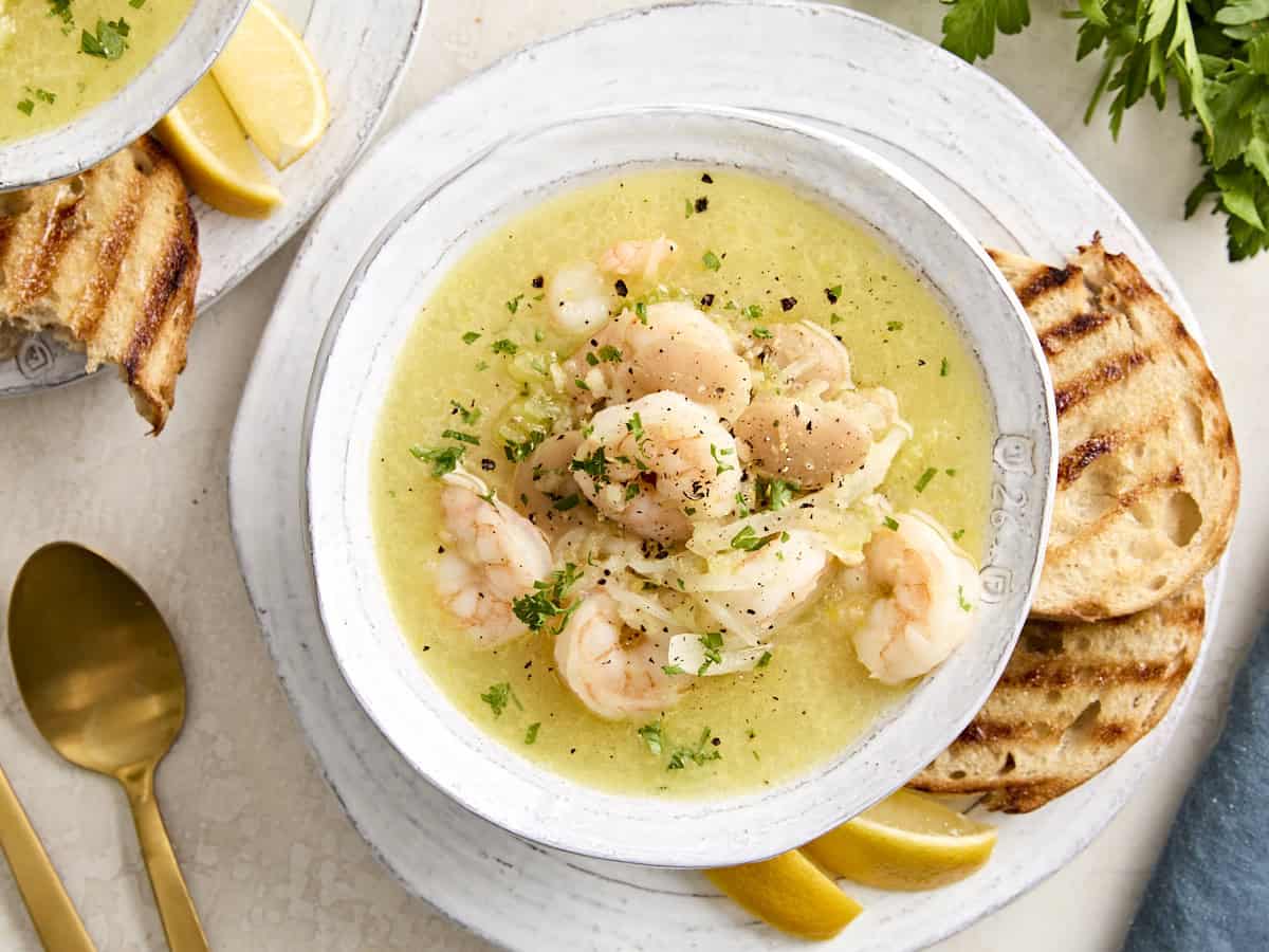 Shrimp and white bean stew in a bowl garnished with fresh herbs