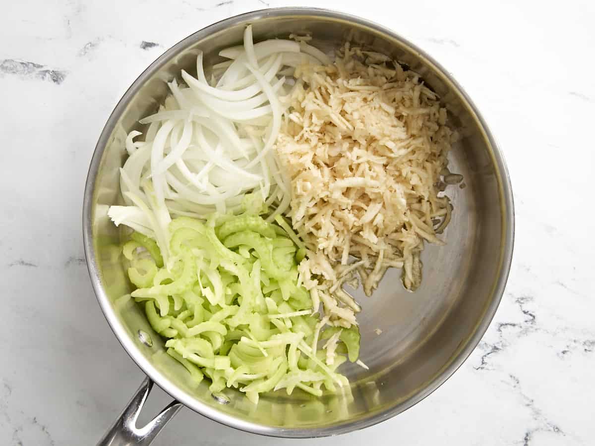 sliced onion, parsnip, and celery in a skillet