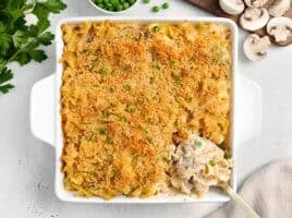 Overhead view of tuna noodle casserole in a casserole dish with a serving spoon.