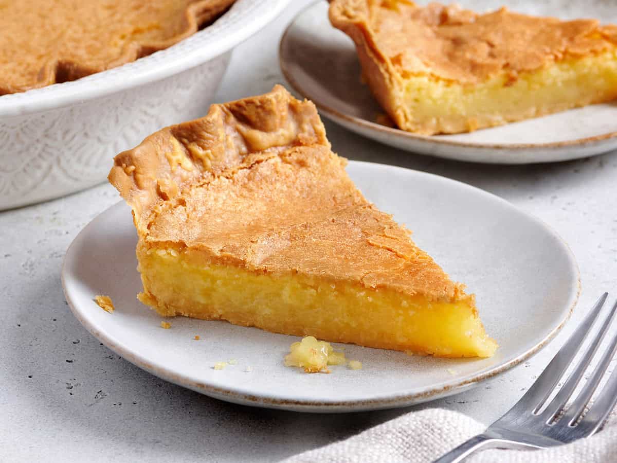 Side view of a slice of homemade chess pie on a plate.
