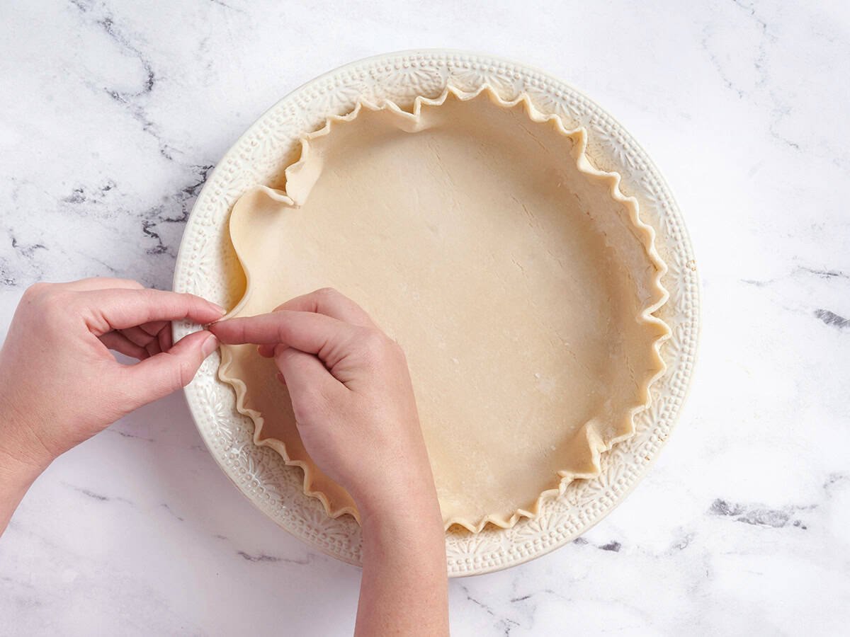 A hand crimping pie crust.