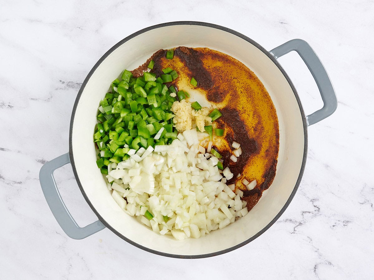 diced onion and bell pepper and minced garlic ingredients for vegetarian chili being cooked