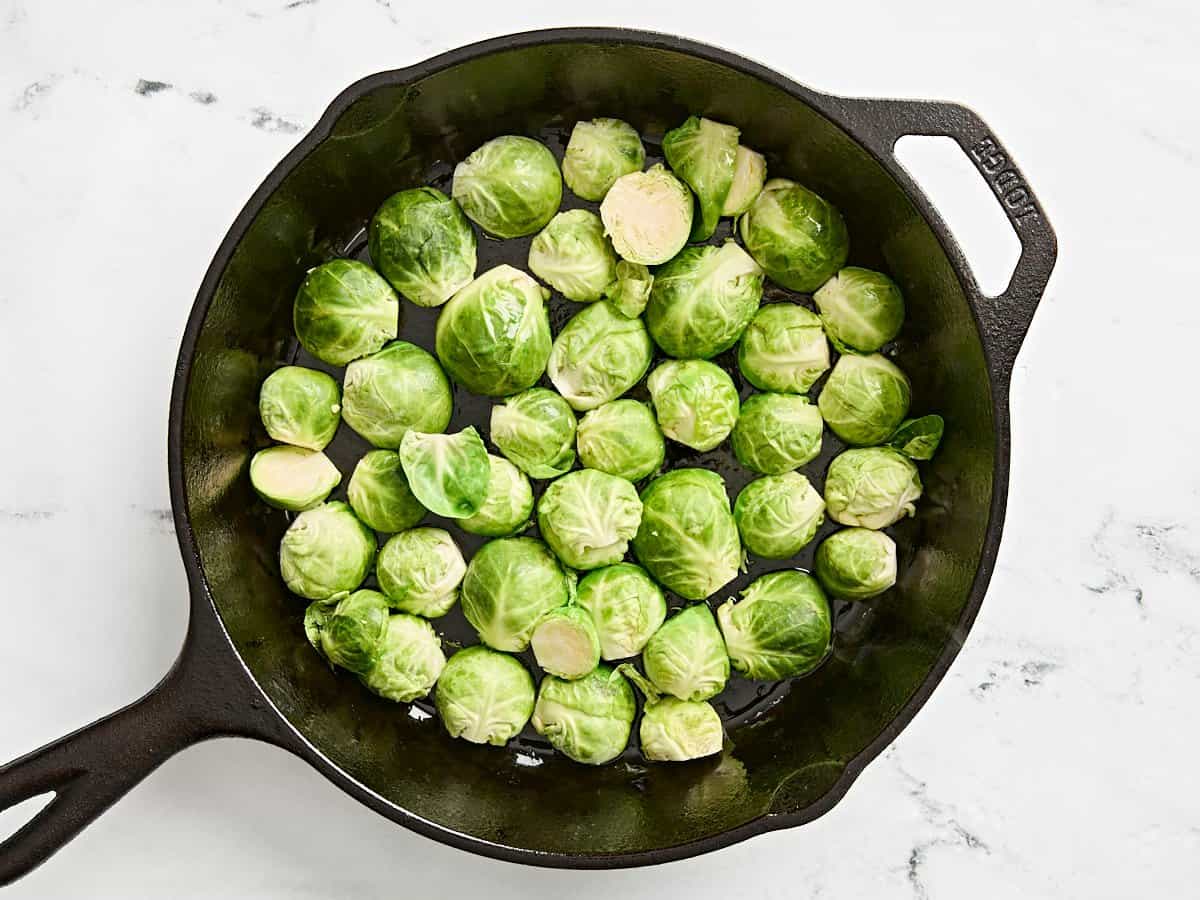 Sliced brussels sprouts in a cast iron skillet.