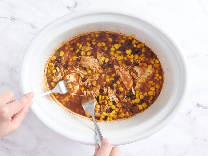 Shredding the chicken in the crockpot.