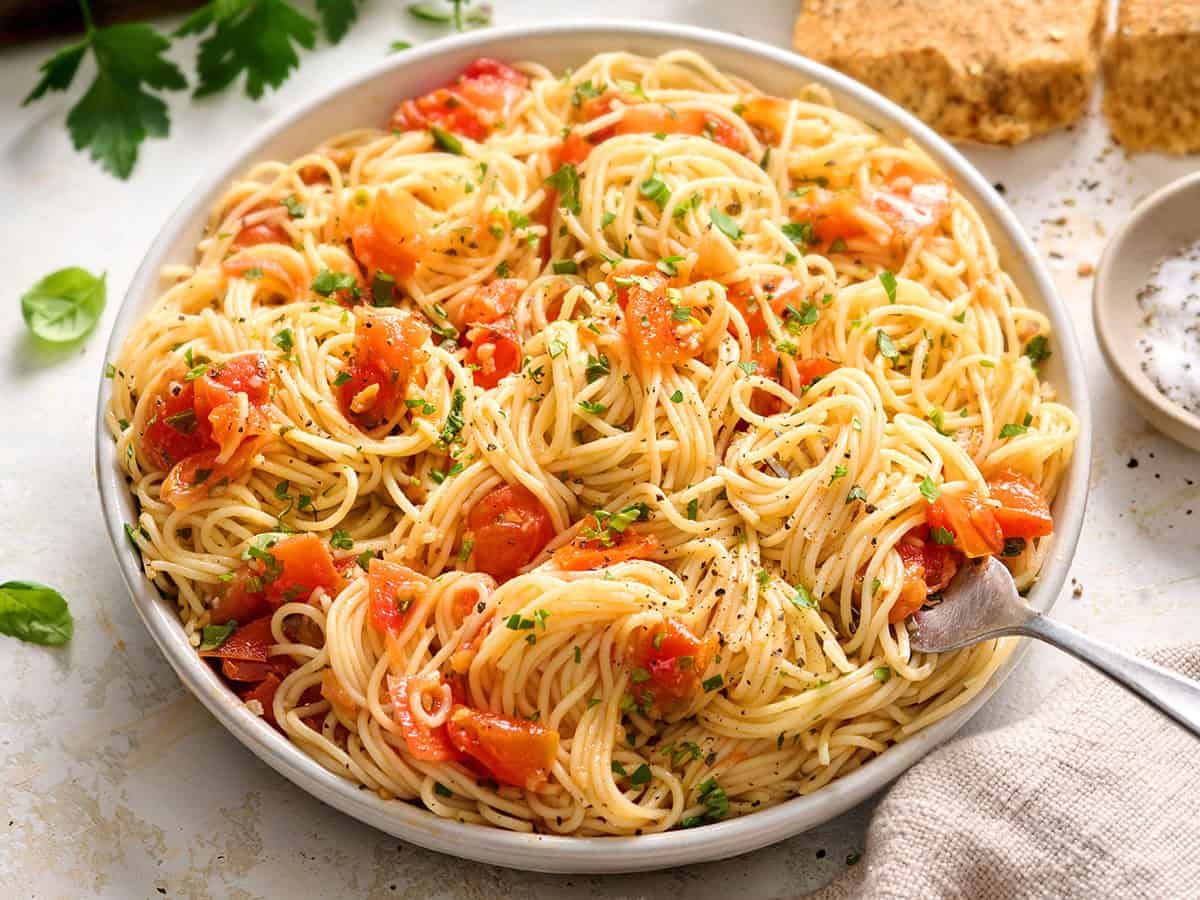 Overhead view of a bowl of angel hair pasta pomodoro with a fork.