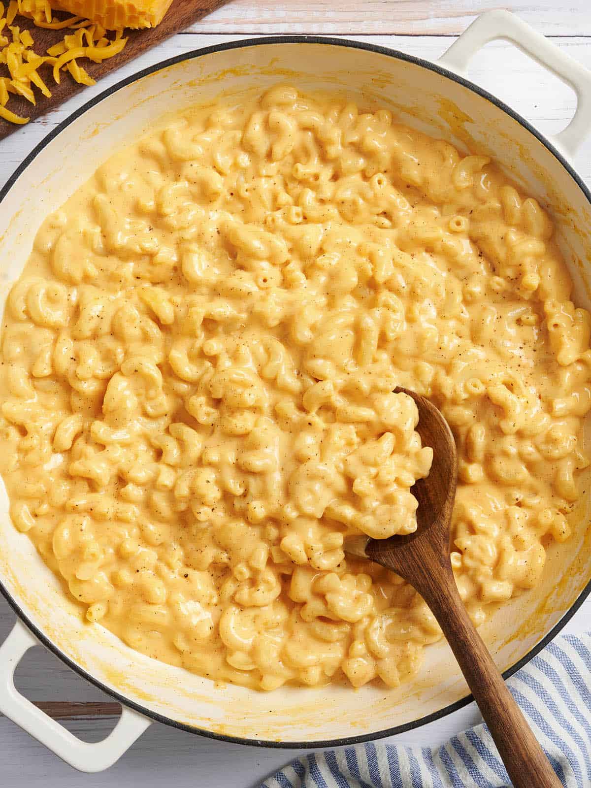 Overhead view of a pot of mac and cheese with a wooden spoon.