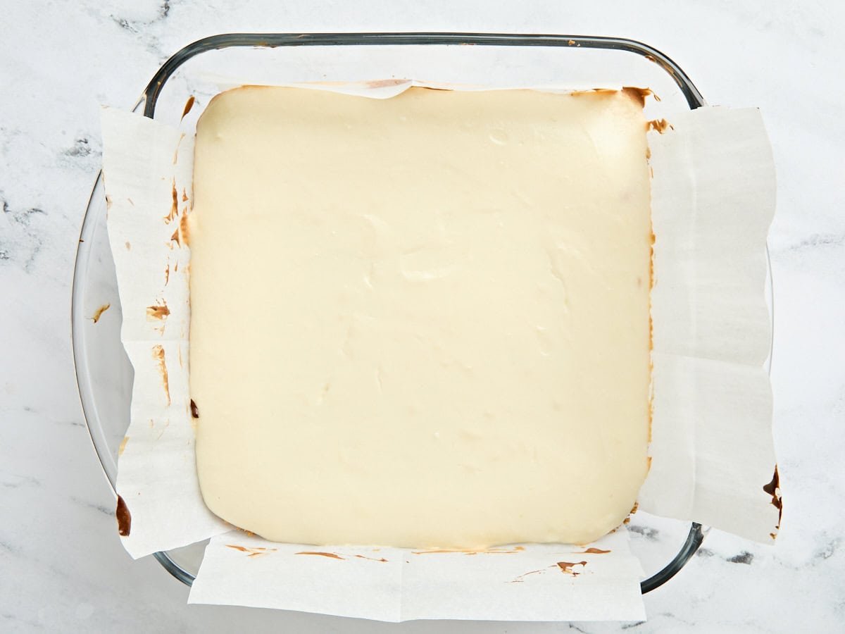 Baked cheesecake bars in a baking dish.