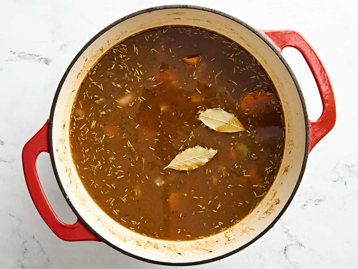 Bay leaves added to beef stew in a dutch oven.