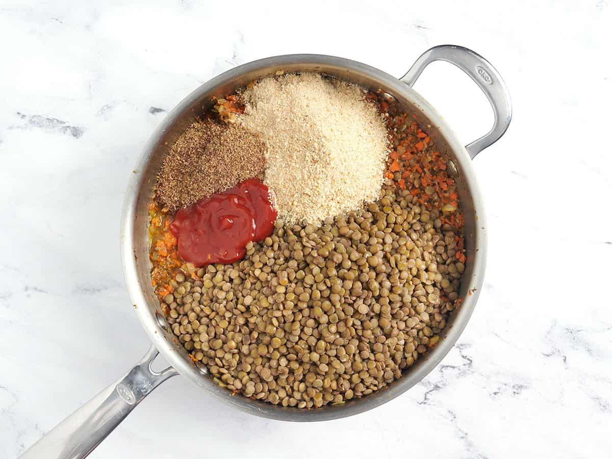 Breadcrumbs, lentils, ketchup, flax, and soy sauce in saucepan.
