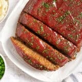Overhead view of of a vegetarian lentil meatloaf with half cut into slices.