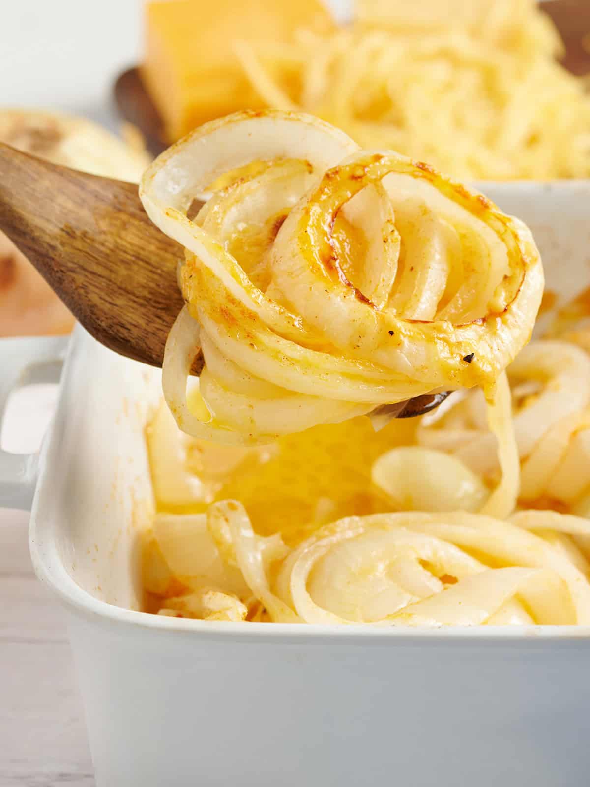 Side view of a baking dish of Tennessee onions with a spatula taking some.