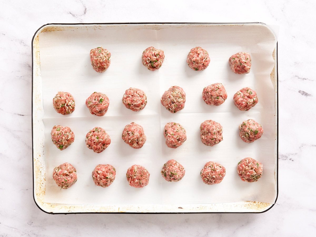 Formed meatballs on a baking sheet.