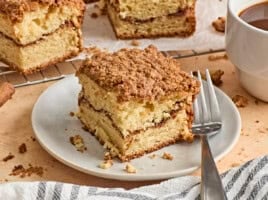 Side view of a slice of coffee cake on a plate with a fork.